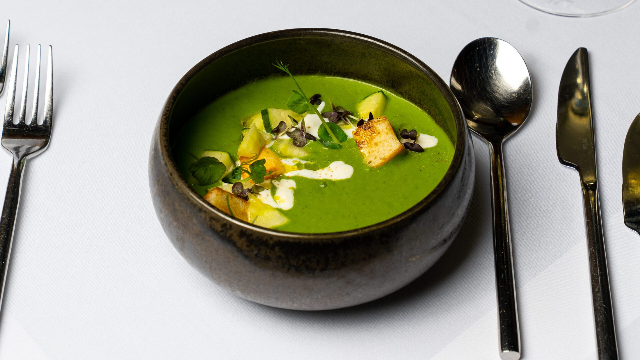 Grüne Suppe im dunklen Teller